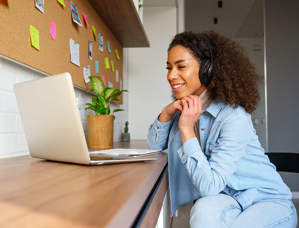 Black mixed heritage woman sitting in front of lap top