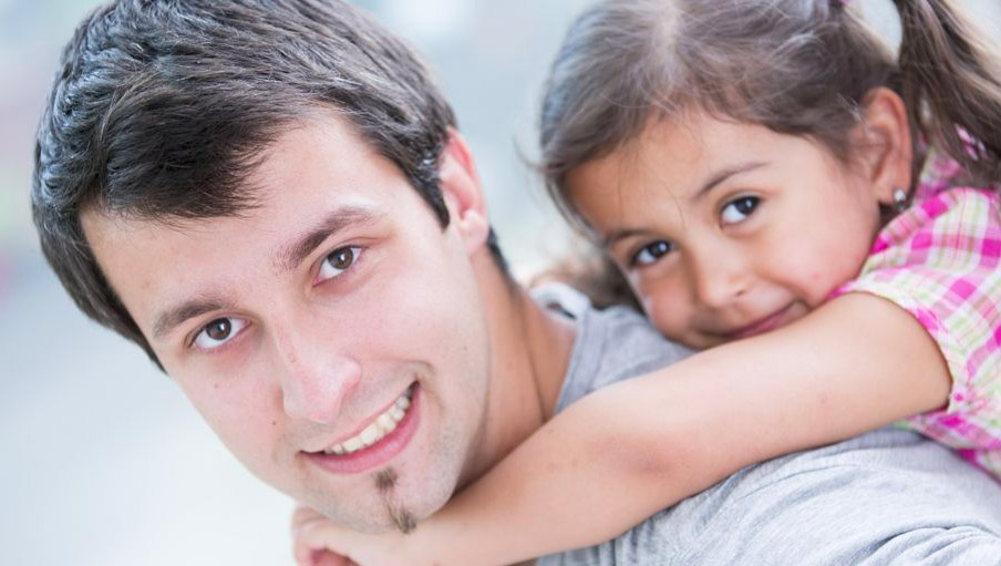 White father giving daughter a piggy back