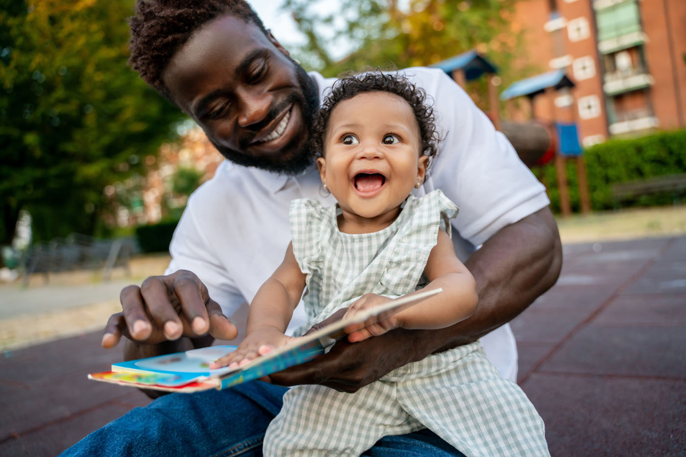 Happy child learning to read assisted by her parent
