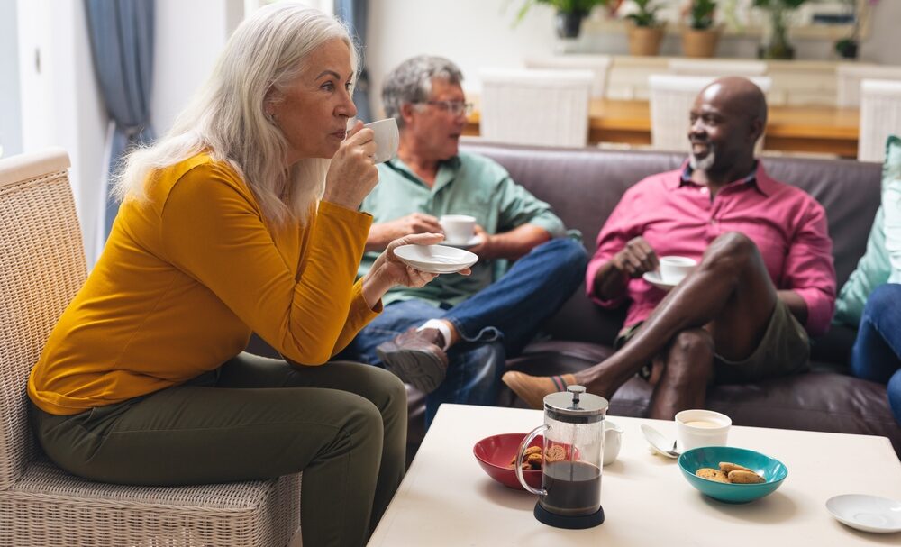 Senior,Woman,Drinking,Coffee,While,Multiracial,Friends,Talking,In,Background adoptee support north london